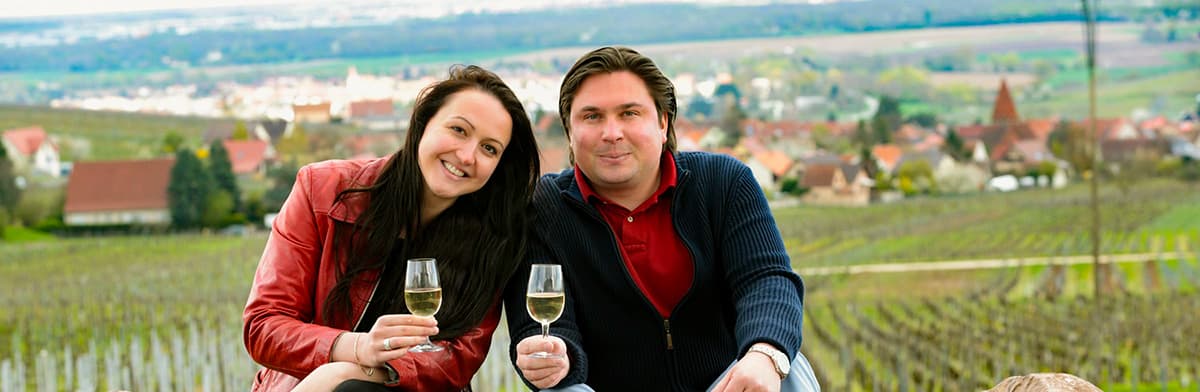 Mann und Frau mit Weißweingläsern in der Hand