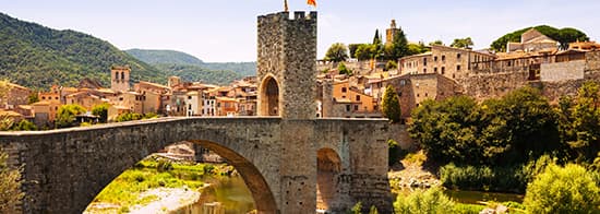 Alte Brücke mit Turm darunter ein Fluss; in Katalonien 