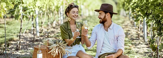 Ein Paar genießt Pinot Grigio während eines Picknicks zwischen Reben