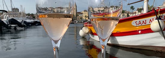 Weißwein in Gläsern vor Boot auf Wasser