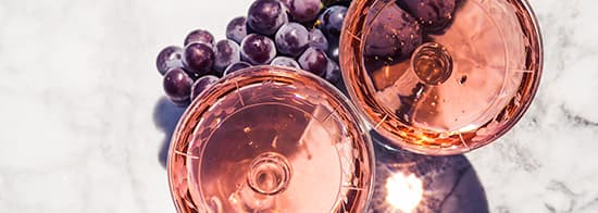 Zwei Gläser mit Roséwein und blaue Trauben