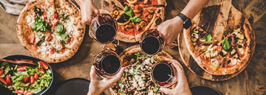 Pizza und Rotwein auf Tisch