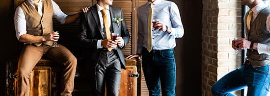 Männer in Anzügen trinken Wein