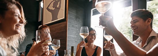 Menschen stoßen mit Weingläsern an