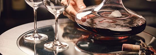 Rotweingläser und Dekanter mit Rotwein auf Tisch