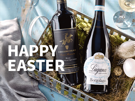 Meravino Weinaktion mit dem Slogan "Happy Easter". Im Hintergrund zwei Flaschen Wein in einem Osterkörbchen.